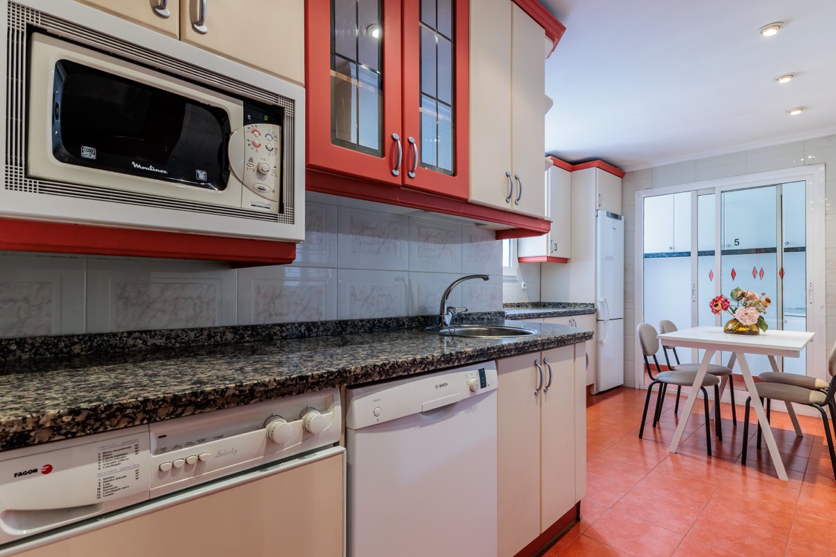 Cocina equipada con mesa y sillas para comer, en el piso de Velázquez