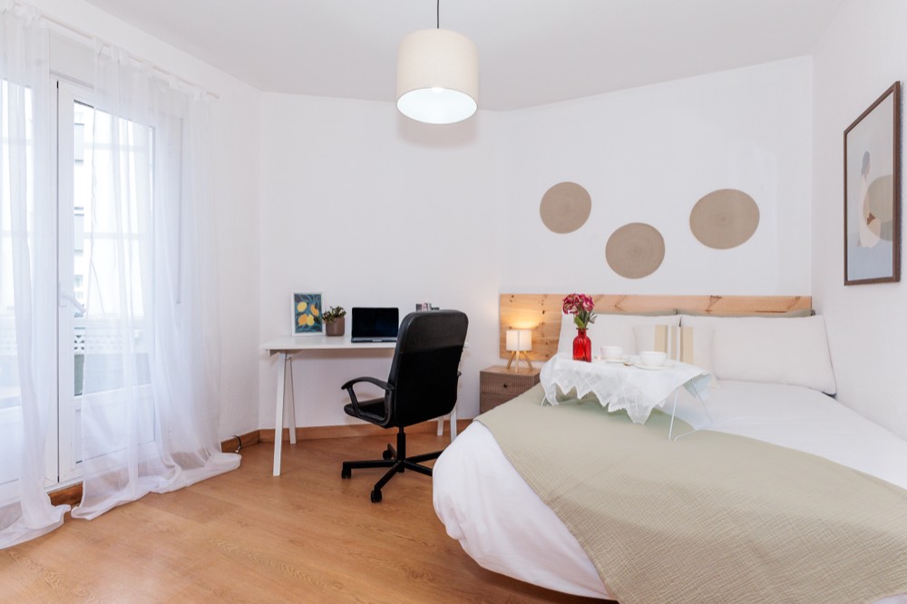 Habitación con escritorio junto al balcón en un piso de La Palomera
