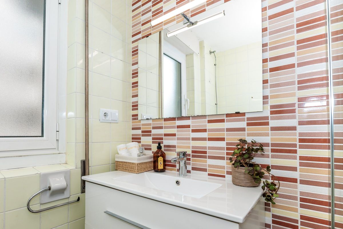 Baño reformado con lavabo y azulejo de colores
