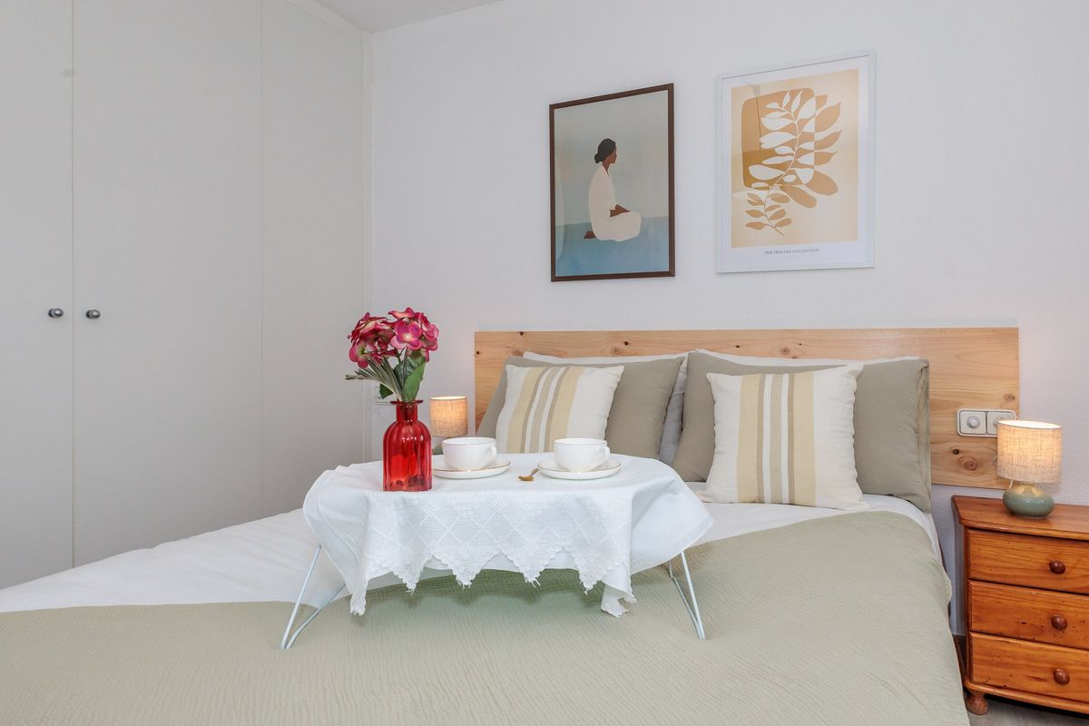 Habitación con cama de matrimonio, lámparas y cuadros