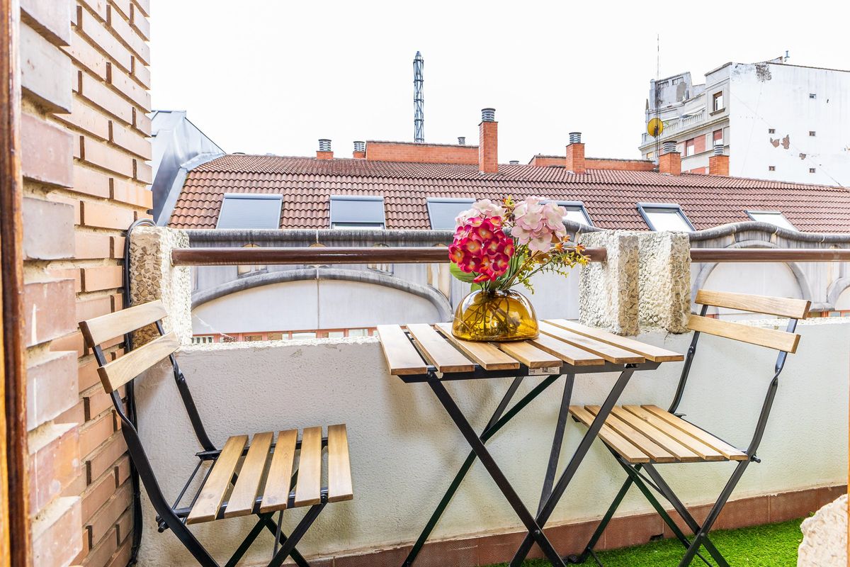 Terraza con mesa, sillas plegables y flores