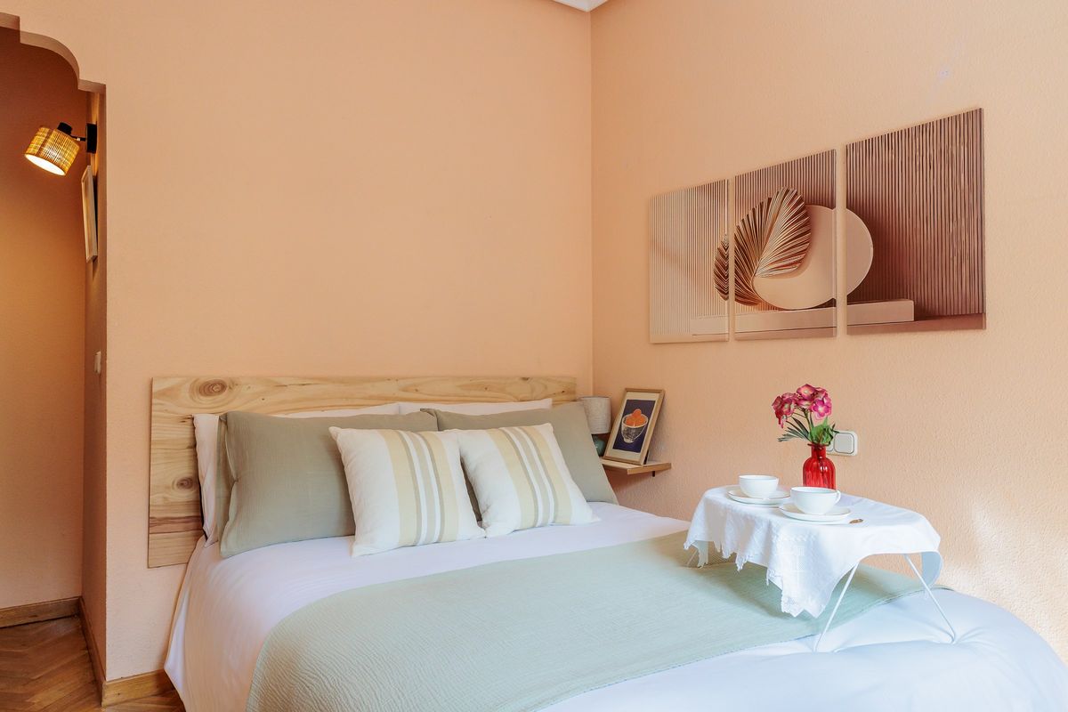Habitación con pared melocotón y cama de matrimonio