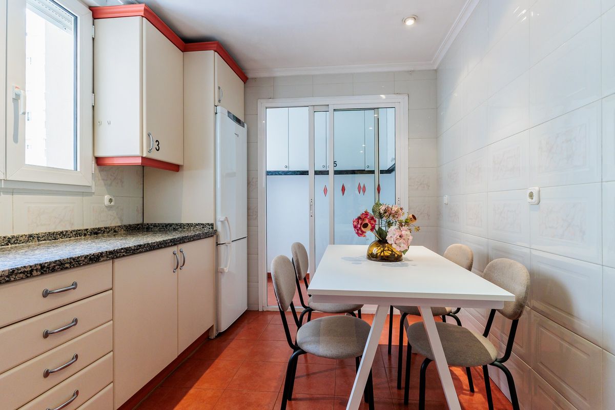 Cocina con mesa y sillas junto a la ventana