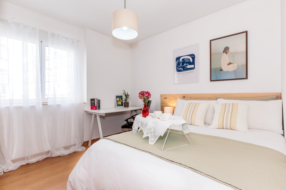 Habitación individual con cama, escritorio blanco y silla de oficina